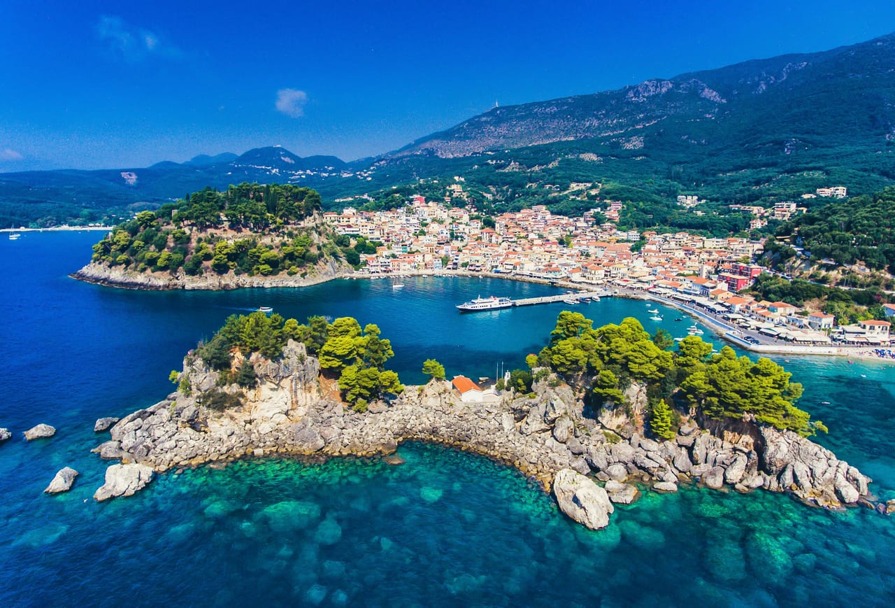 Parga et l’îlot de Panagia vus du ciel, entre la mer Ionienne turquoise et les collines.
