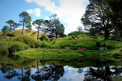 Le porte rotonde delle tane degli hobbit, riflesse nello stagno di Hobbiton.