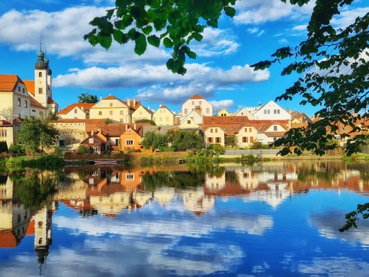 Les façades de Telč et leur clocher, reflétés dans l’étang.